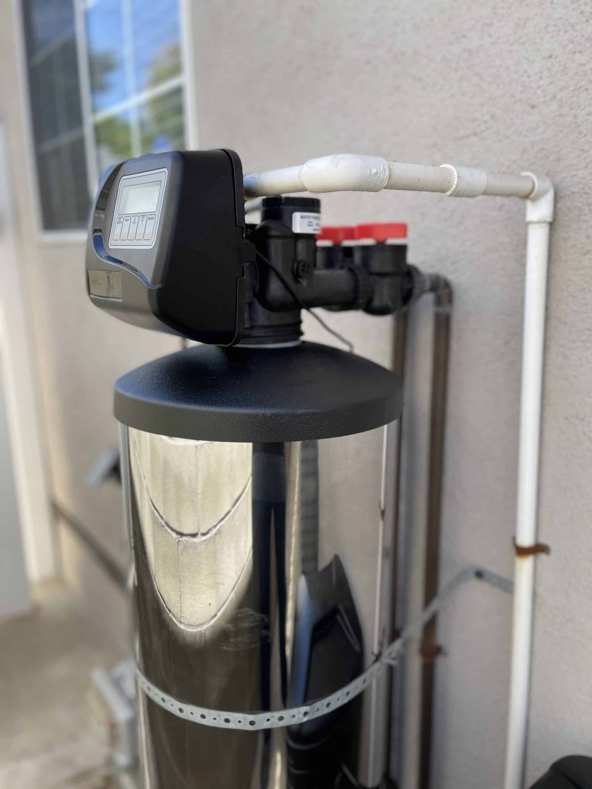 IMG_0488 side view of the praz signature system for hard water treatment attached to a pipeline in the side of a house